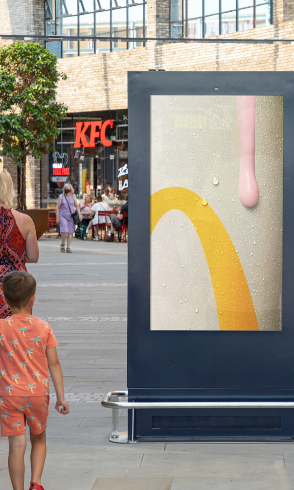 High-footfall city centre digital advertising screen positioned outside retail and food outlets, showcasing premium out-of-home advertising in a busy pedestrian environment.